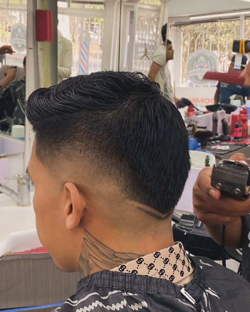 Fade alto con diseño de doble línea angular rasurada en la nuca
